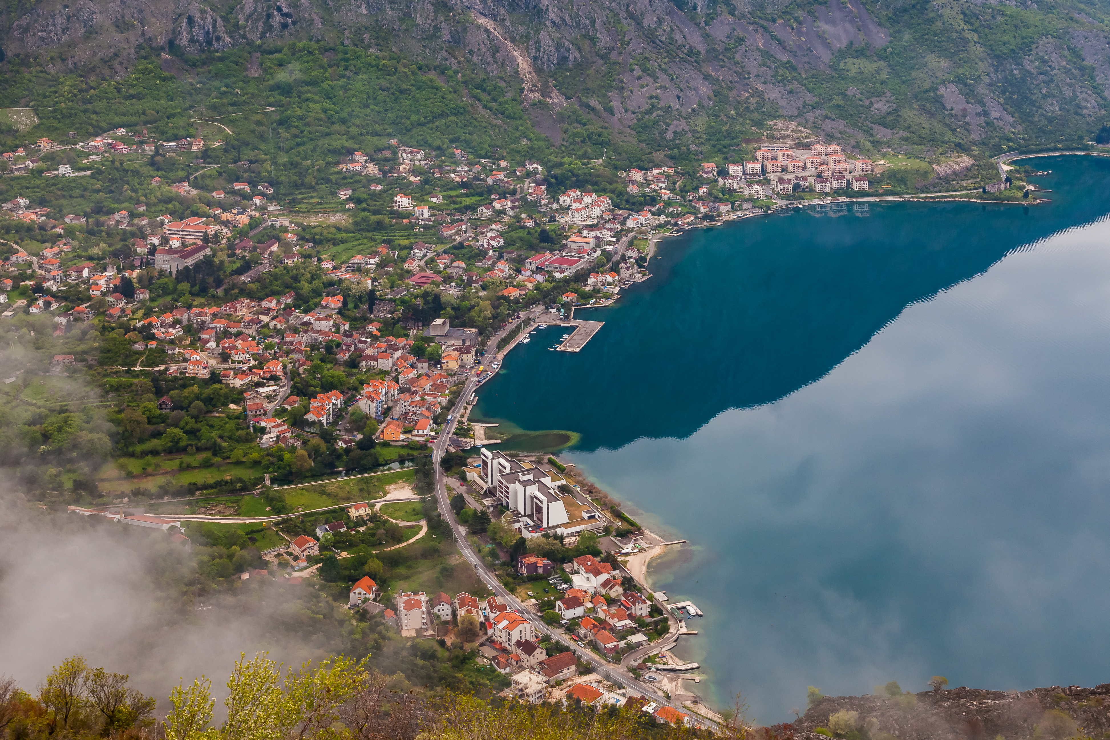 Luftaufnahme von Risan am Kopf der Bucht von Kotor, mit dem aufsteigenden Orjen-Massiv dahinter, Montenegro