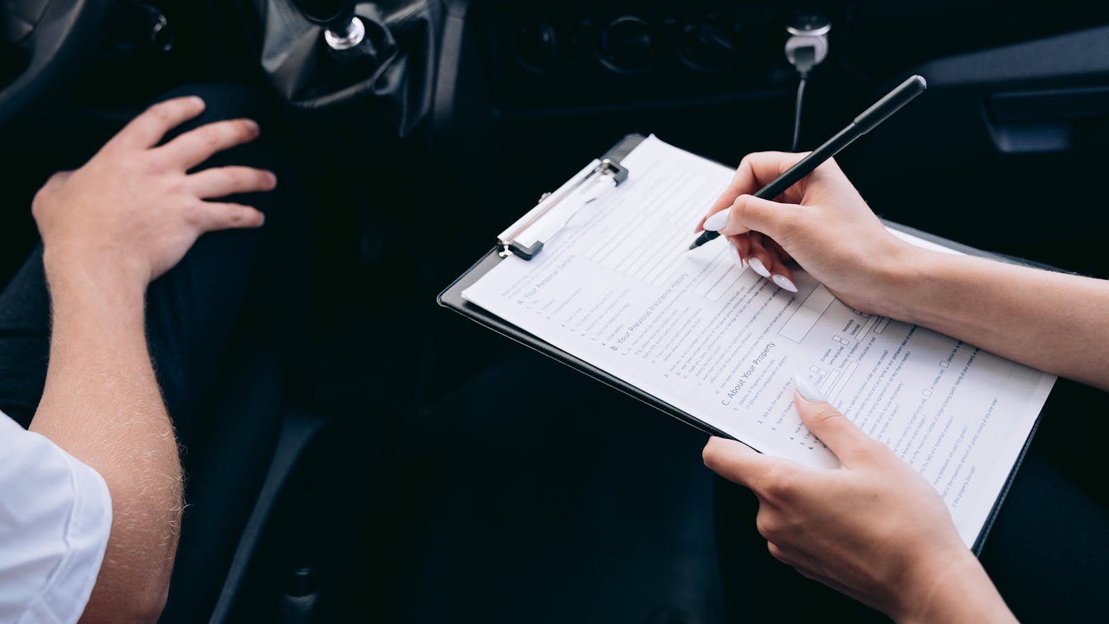 Signing a rental contract on a clipboard inside the vehicle