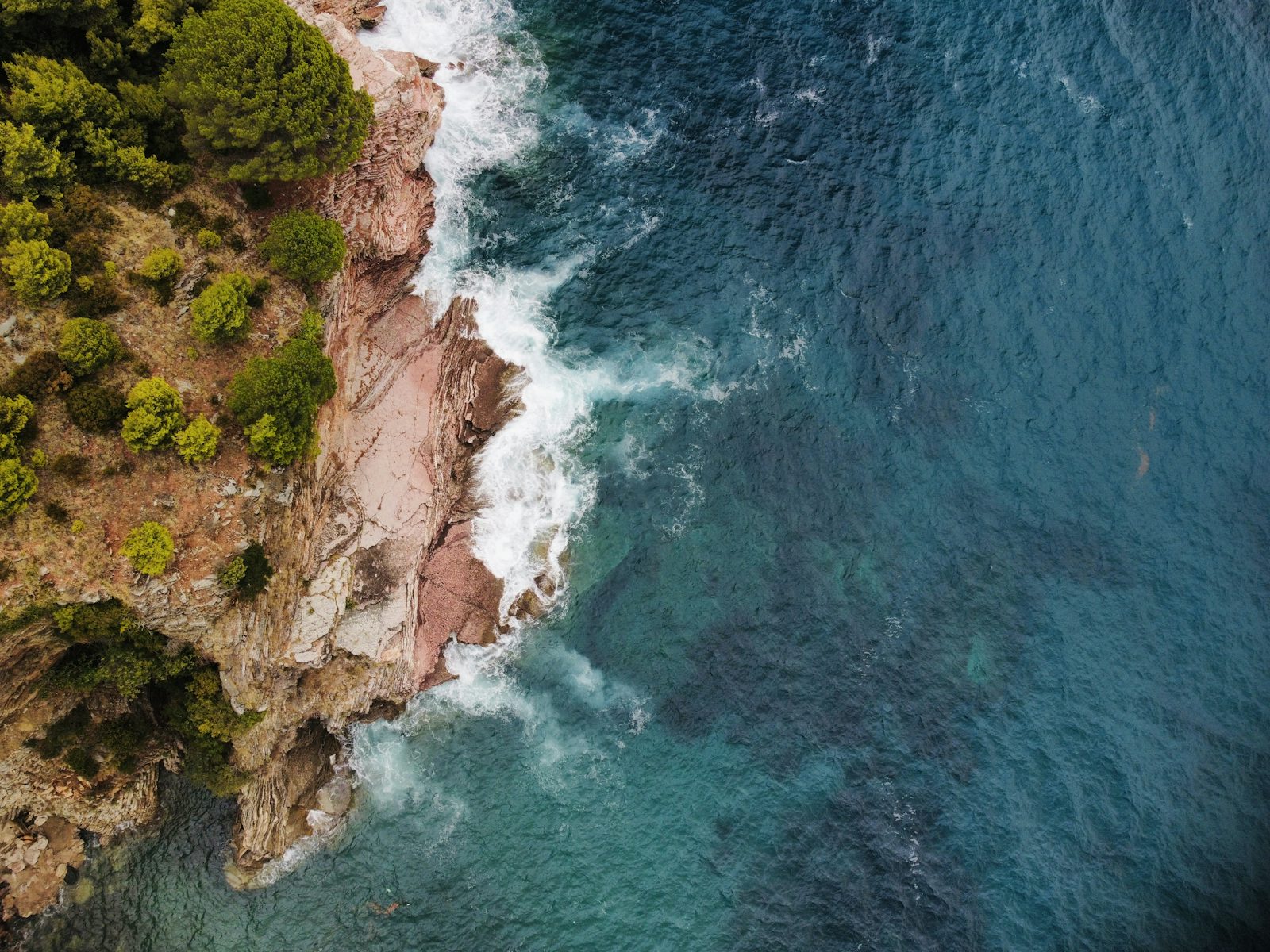 Rocky headland and turquoise water at Rafailovići, Montenegro (photo by Antonio Janeski on Unsplash)
